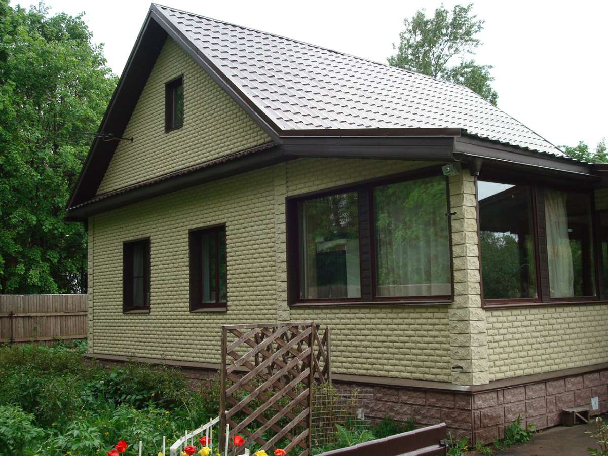 Небольшой деревянный дом, облицованный плиткой колотая фаска.  